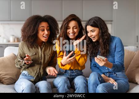 Drei Frauen reagieren auf Inhalte auf dem Smartphone Stockfoto