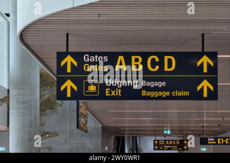 Schild am flughafen (Gate a b c d existiert), englisch und dänisch in Kopenhagen (modern, Richtung), weiße Decke Stockfoto