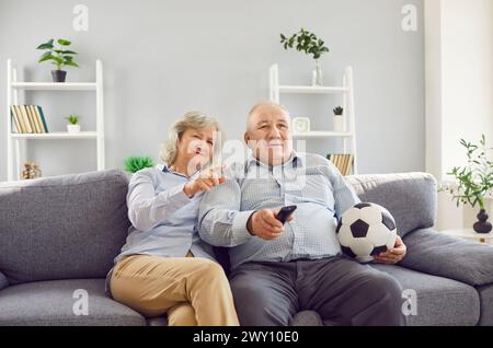 Älteres Familienpaar Sieht Gemeinsam Football Match Im Fernsehen An Stockfoto