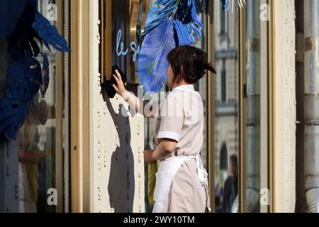 In der Stadt putzen, asiatische Frau wäscht die Restaurantfassade Stockfoto