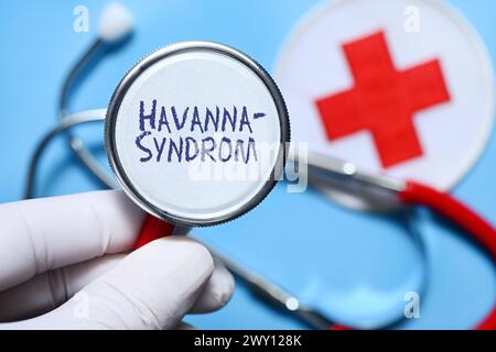 FOTOMONTAGE, Hand halten Stethoskop mit Aufschrift Havanna-Syndrom *** FOTOMONTAGE, Hand halten Stethoskop mit Inschrift Havanna-Syndrom Stockfoto