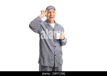 Älterer Mann im Pyjama mit einer Schlafmaske, die eine Tasse isoliert auf weißem Hintergrund hält Stockfoto