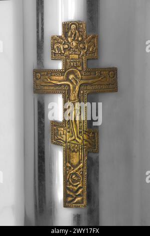 Goldenes Metall russisches orthodoxes Kreuz mit drei Stangen auf Metallkiste Stockfoto