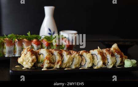 August 2017 - zwei Sushi-Brötchen, darunter vorne ein frittiertes kalifornisches Brötchen mit Sauce, Stockfoto