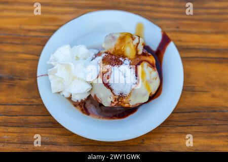 Nahaufnahme verschiedener Eissorten mit Sirup auf einem Restauranttisch. Stockfoto