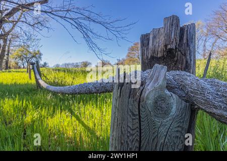 Eine Nahaufnahme eines rustikalen Zauns mit einem Seil auf einem ländlichen Feld Stockfoto
