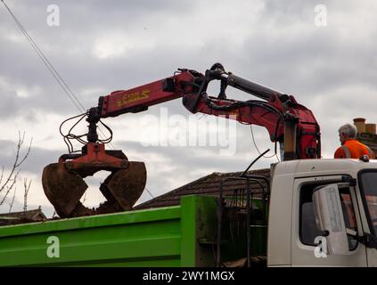 Schutt-Greifwagen entfernen Stein und Erde mit einem Greifschaufel an einem Kran. Stockfoto