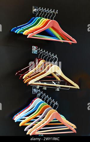 Bunte Kleiderbügel an Kleiderstange im Laden Stockfoto