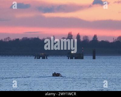 Sheerness, Kent, Großbritannien. April 2024. Wetter in Großbritannien: Farbenfroher Sonnenuntergang in Sheerness, Kent. RNLI-Rettungsboot bei Sonnenuntergang. Quelle: James Bell/Alamy Live News Stockfoto