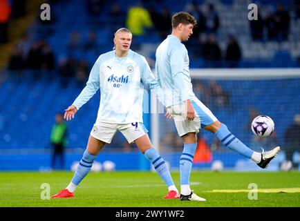 Erling Haaland von Manchester City spricht mit Teamkollege John Stones während des Vorspiels vor dem Premier League-Spiel im Etihad Stadium in Manchester. Bilddatum: Mittwoch, 3. April 2024. Stockfoto