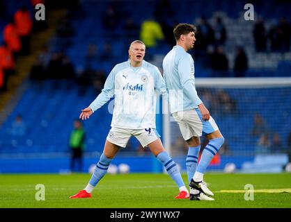 Erling Haaland von Manchester City spricht mit Teamkollege John Stones während des Vorspiels vor dem Premier League-Spiel im Etihad Stadium in Manchester. Bilddatum: Mittwoch, 3. April 2024. Stockfoto