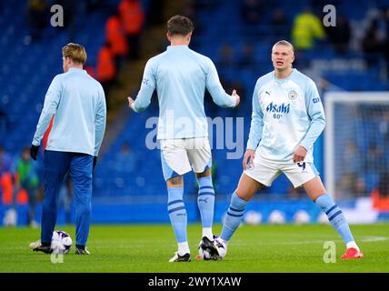 Erling Haaland von Manchester City spricht mit Teamkollege John Stones während des Vorspiels vor dem Premier League-Spiel im Etihad Stadium in Manchester. Bilddatum: Mittwoch, 3. April 2024. Stockfoto