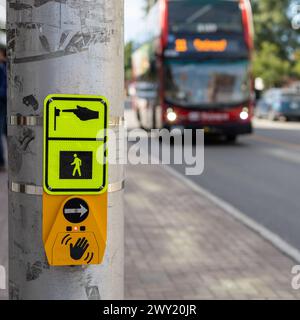 Ottawa, Kanada - 16. September 2023: Bus auf der Straße, der sich einer Kreuzung nähert, mit Schild für Fußgänger, die die Straße überqueren Stockfoto