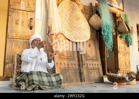 Der alte Mann webt einen traditionellen Metallfischkäfig in Darb Al Saai, der zum Nationalfeiertag in Katar feiert. Stockfoto