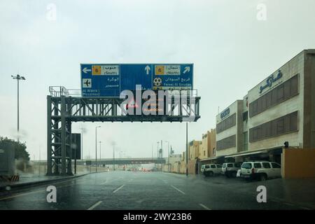 Nieseln Sie abends auf die Windschutzscheibe. Verschwommene Landschaft mit regnerischem Tag. Blick vom Autositz in Doha Qatar Stockfoto