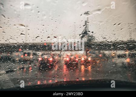 Nieseln Sie abends auf die Windschutzscheibe. Verschwommene Landschaft mit regnerischem Tag. Blick vom Autositz in Doha Qatar Stockfoto