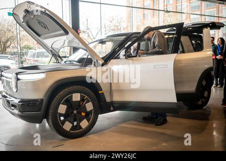 Fans von Rivian Elektrofahrzeugen, die am Mittwoch, den 27. März 2024, im Rivian Spaces im Meatpacking District in New York einen Prototyp des Rivian R2 bewundern. Rivian gab bekannt, dass es über 68.000 Reservierungen für die neuen 45.000 Dollar EVV erhalten habe, die erst im ersten Halbjahr 2026 in Produktion gehen werden. (© Richard B. Levine) Stockfoto
