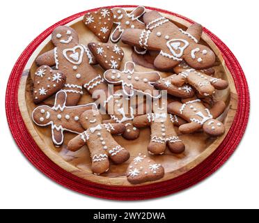 Holzteller mit Lebkuchenmännern auf weißem Hintergrund. Datei enthält Beschneidungspfad. Stockfoto