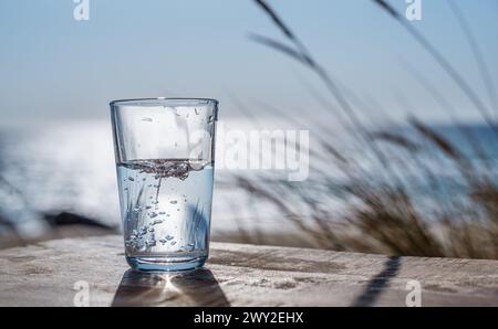 Gießen Sie Wasser aus der Plastikflasche in ein Glas. Naturhintergrund. Stockfoto