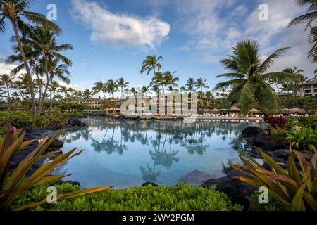 Palmen spiegeln sich im wunderschönen türkisfarbenen Wasser eines der luxuriösen Swimmingpools im Grand Hyatt Kauai Resort and Spa in Koloa, Hawaii. Stockfoto