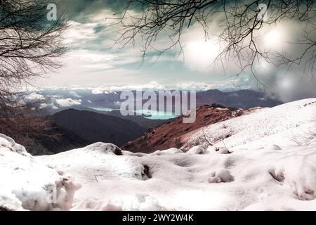 Eindrucksvoller Blick vom Mottarone Berg an einem Wintermorgen, mit See Orta und verschneiten Bergen. Piemont - Italien. Stockfoto