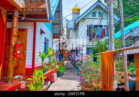 Die enge Straße, flankiert von Pfahlhäusern und Pflanzen in Töpfen, Ko Panyi Fischerdorf, Phang Nga Bay, Thailand Stockfoto