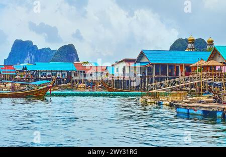 Die kleinen Piers, alten Kajaks und Fischfarmen am Ufer des muslimischen Stelzendorfes Ko Panyi (Koh Panyee) in der Provinz Phang Nga, Thailand Stockfoto