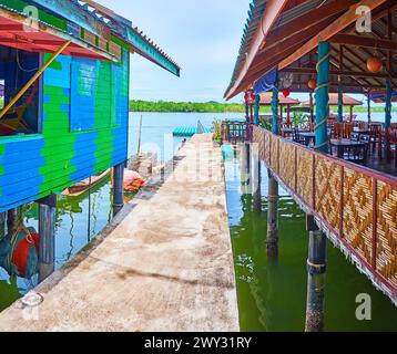 Der Pier zwischen dem Pfahlhaus und der Terrasse des Touristenrestaurants im Dorf Ko Panyi, Phang Nga Bay, Thailand Stockfoto