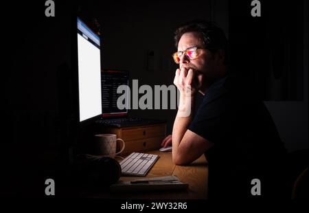 Professionelle Person, die nachts am Computer arbeitet Stockfoto