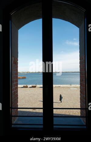 Blick durch ein Fenster auf die Fußgängerpromenade im Stralsund-Hafen am Strelasund in Deutschland Stockfoto