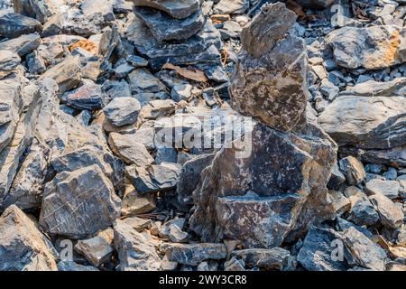 Stapel flacher Felsen, die übereinander balanciert sind, neben anderen losen Felsen und Steinen in Südkorea Stockfoto