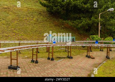 Miniatur-Außenbahnhof, umgeben von Bäumen an einem bewölkten Tag, in Südkorea Stockfoto