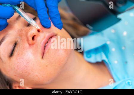 Nahaufnahme einer Frau von oben, die eine botox-Injektion in die Lippen erhalten hat, die auf einer Liege in der Klinik liegen Stockfoto