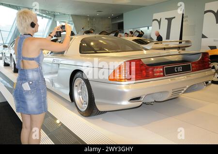 Museum, Mercedes-Benz Museum, Stuttgart, Frau fotografiert das Heck eines silbernen Mercedes-Benz C112 in einem Ausstellungsraum, Mercedes-Benz Museum Stockfoto