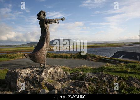 Eine Aufnahme von Niall Brutons Statue, die am Ufer wartet und eine Frau mit ausgestreckten Armen zeigt, um die Seefahrer zu erkennen Stockfoto