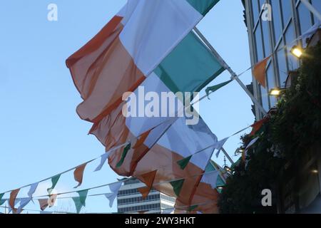 Die irischen Trikolore hängen an einem sonnigen Tag in der Brise. Dublin, Irland Stockfoto