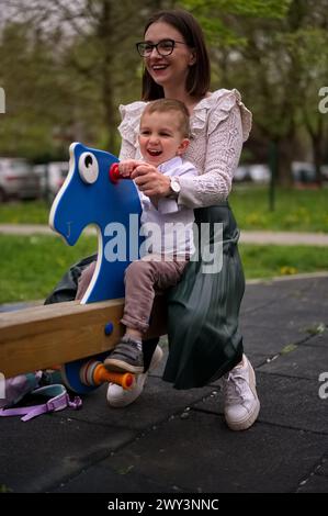 Mutter und ihr Kleinkind haben Spaß auf dem Spielplatz Stockfoto