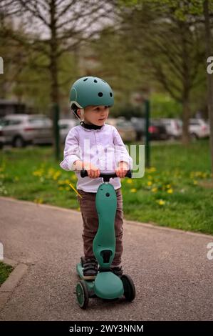 Kleines Kleinkind auf dem Roller im Park Stockfoto