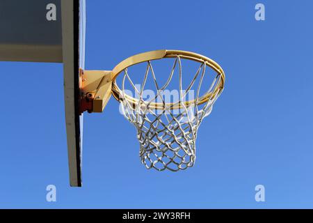 Basketballkorb und Rückenbrett vor blauem Himmel Stockfoto