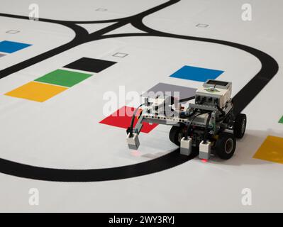 Roboter mit Rädern bewegt sich entlang der schwarzen Linie, selektiver Fokus. Leitung folgt mit einem Sensor Stockfoto