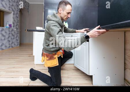 Ein älterer Mann zerlegt die Wohnküche außer Betrieb Stockfoto