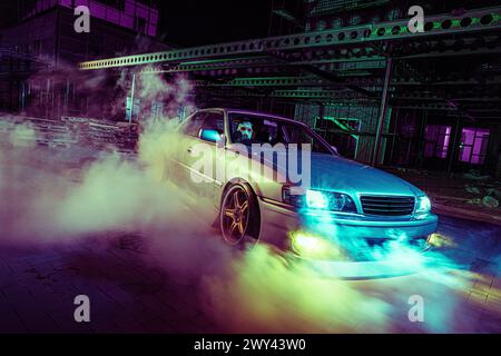 High Speed Night Drift mit maßgeschneidertem Sportwagen in urbaner Umgebung Stockfoto