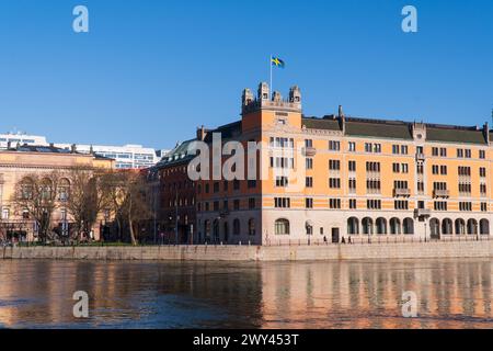 Rosenbad, die Regierungsgebäude in Stockholm, Schweden. Schwedische Flagge, blauer Himmel, Anfang Frühling. Heller Sonnenschein. Stockfoto