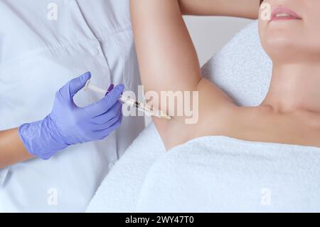 Der Arzt führt intramuskuläre Injektionen von Botulinumtoxin in den Achselbereich gegen Hyperhidrose durch. Stockfoto