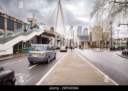 Blick von der Straße auf die Golden Jubilee Bridge, die die Themse überquert. Fußgänger überqueren die Themse auf der Golden Jubilee Bridge. Stockfoto
