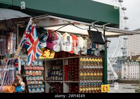 Ein Touristenstand, an dem Souvenirs aus London verkauft werden, mit dem London Eye oder dem Millennium Wheel in der Ferne. Reise und Tourismus, Wirtschaft oder BIP-Konzept. Stockfoto
