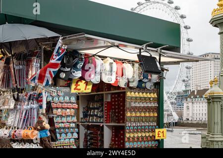 Ein Touristenstand, an dem Souvenirs aus London verkauft werden, mit dem London Eye oder dem Millennium Wheel in der Ferne. Reise und Tourismus, Wirtschaft oder BIP-Konzept. Stockfoto