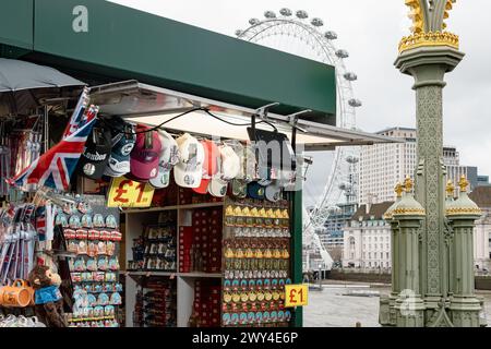 Ein Touristenstand, an dem Souvenirs aus London verkauft werden, mit dem London Eye oder dem Millennium Wheel in der Ferne. Reise und Tourismus, Wirtschaft oder BIP-Konzept. Stockfoto