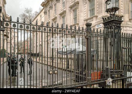 Bewaffnete Polizei hinter den Toren der Downing Street. Die Downing Street 10 ist der Ort des britischen Premierministers. Britische und Weltpolitik. Stockfoto