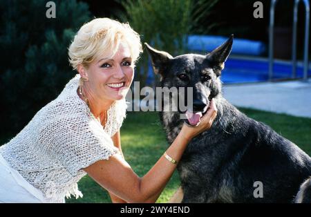 Helena Vondrackova, tschechische Sängerin, Schauspielerin und Musicaldarstellerin, zuhause mit Schäferhund, Deutschland 1995. Stockfoto